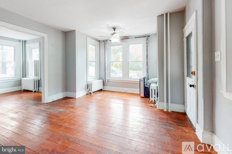 A room with wooden floors and a ceiling fan.