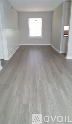 A room with a wooden floor and a window.