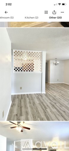 A modern kitchen with wooden flooring and a ceiling fan.