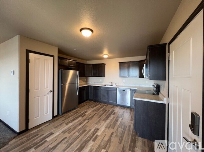 A kitchen with wood flooring and stainless steel appliances.