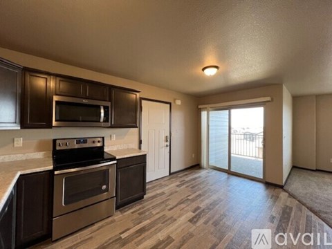 A kitchen with dark brown cabinets and a stainless steel oven.