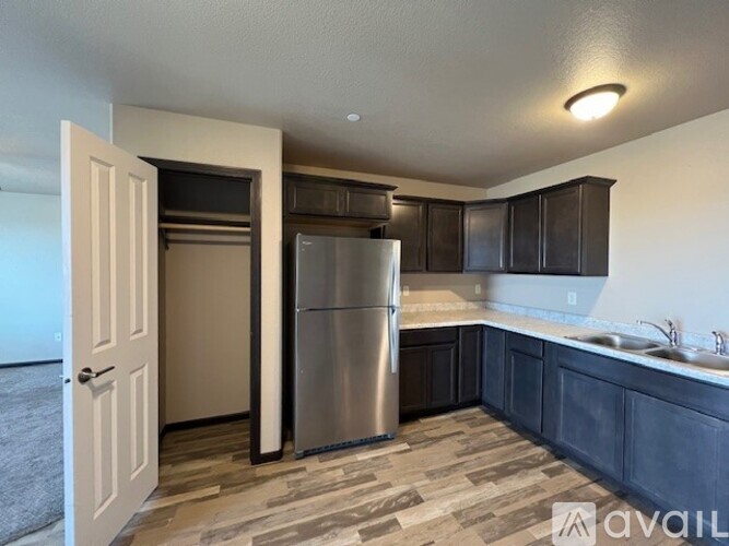 A kitchen with a refrigerator and a sink.