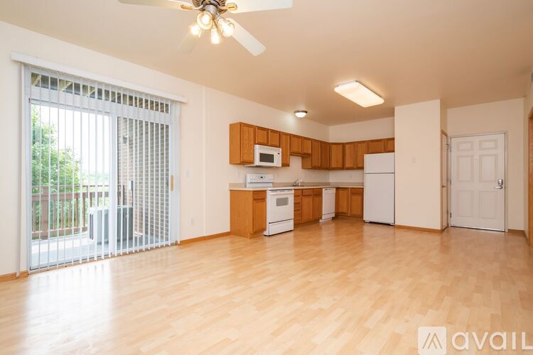 A kitchen with wooden floors and white appliances.