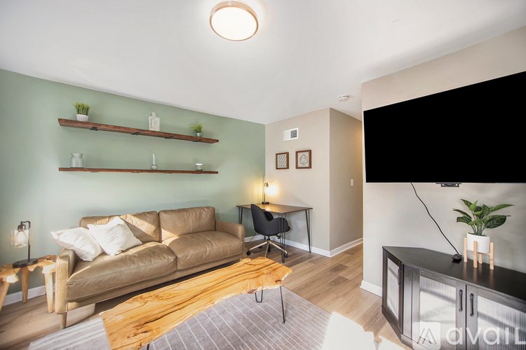 A living room with a brown couch, a wooden table, and a television.