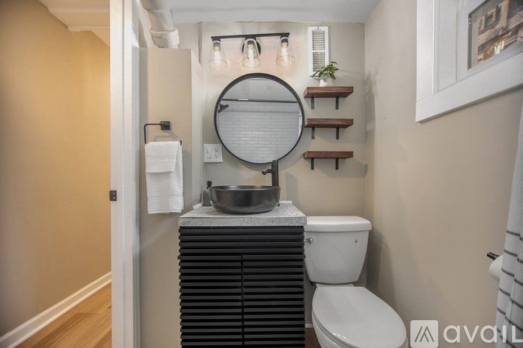 A bathroom with a toilet, sink, and mirror.