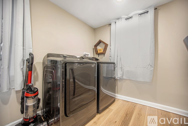 A clean, empty room with a vacuum cleaner and a wall-mounted shelf.