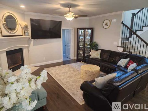 A living room with a black couch and a fireplace.