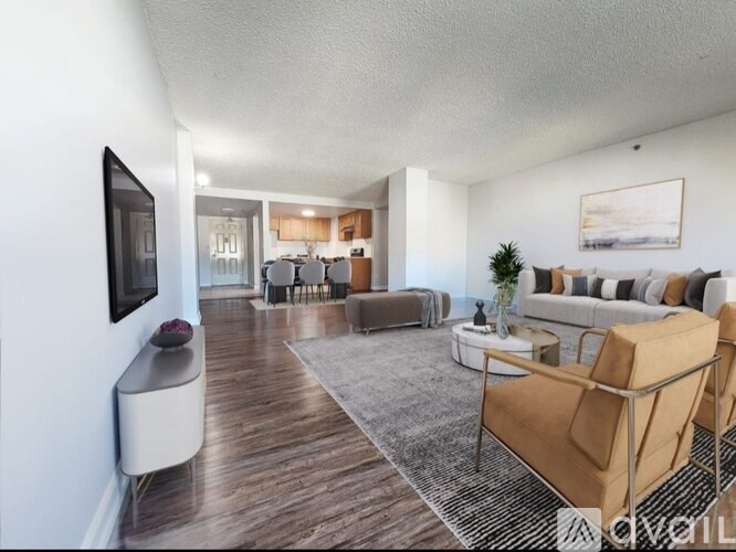 A living room with a brown sofa and a grey rug.