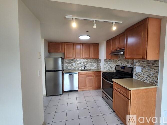 A kitchen with wooden cabinets and a stone backsplash.