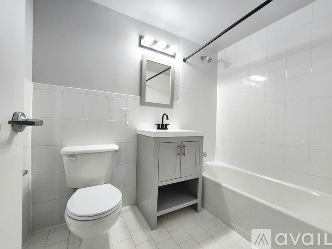 A white toilet sits next to a cabinet with a mirror above it.