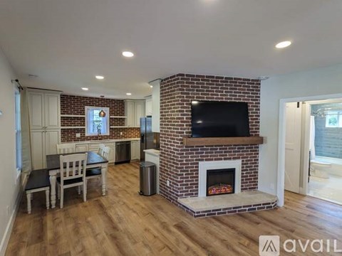A living room with a fireplace and a television on the wall.