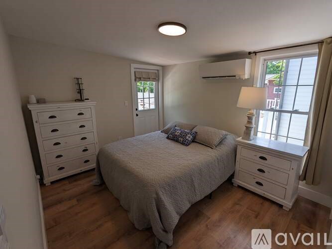 A bedroom with a bed, dresser, and nightstand.
