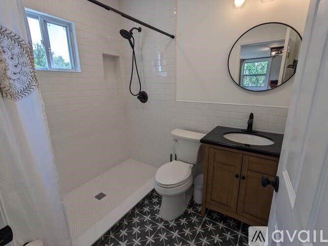 A bathroom with a black and white tiled floor.