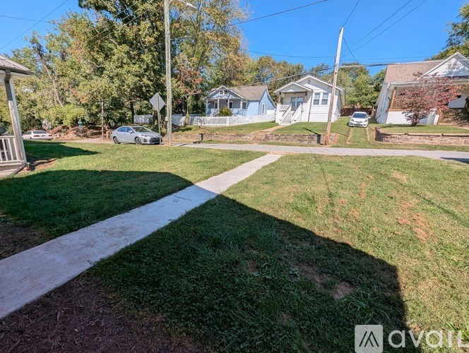 A grassy area with a white line in the middle and houses in the background.