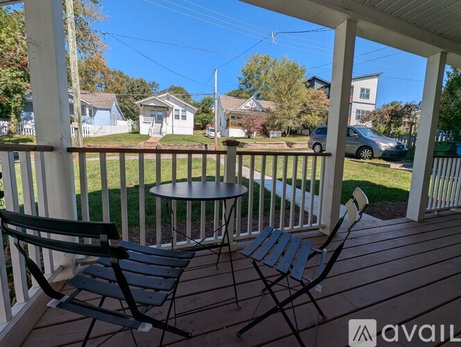A patio with a table and two chairs overlooking a street.