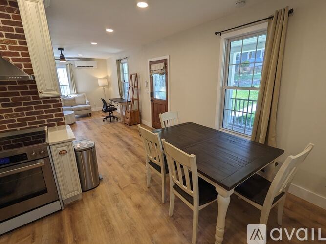 A kitchen with a dining table and chairs in the foreground.