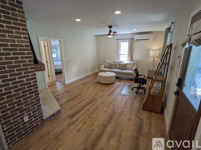 A living room with a brick wall and wooden floors.