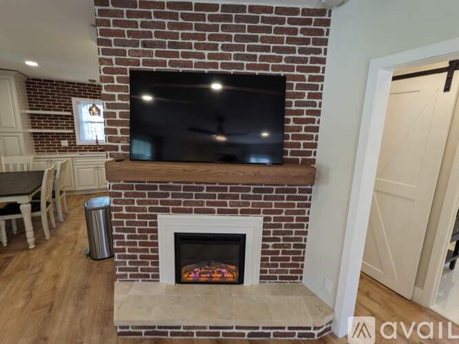 A brick fireplace with a flat screen TV mounted above it.