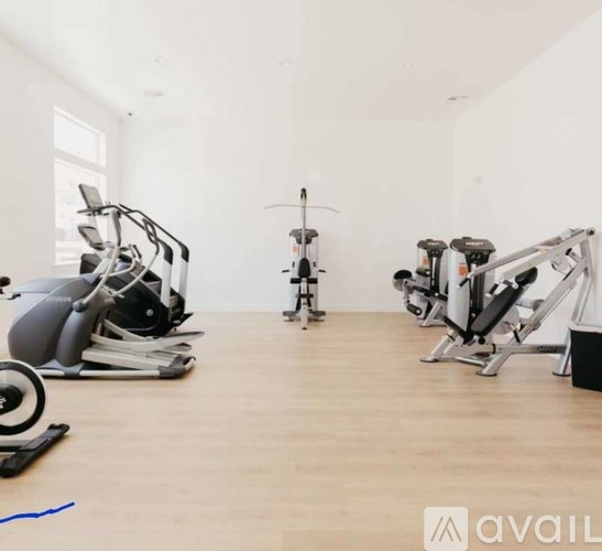 A gym with a variety of exercise equipment including a stationary bike, a rowing machine, and a treadmill.