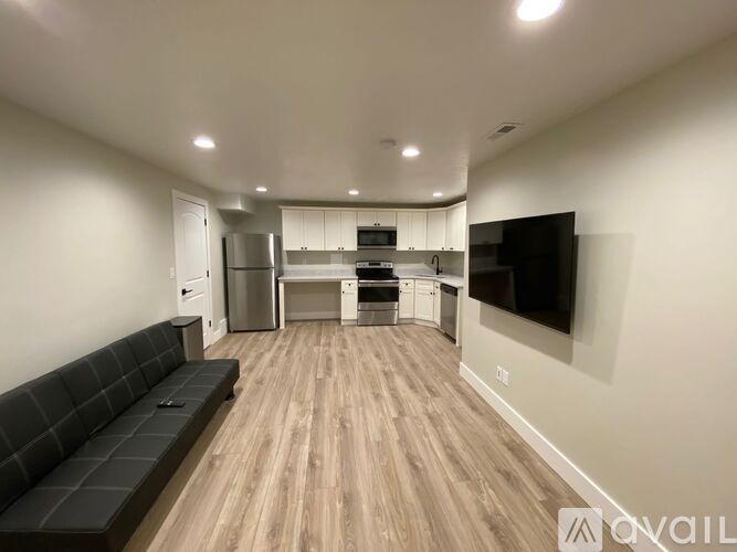 A modern kitchen with a black bench and wooden flooring.
