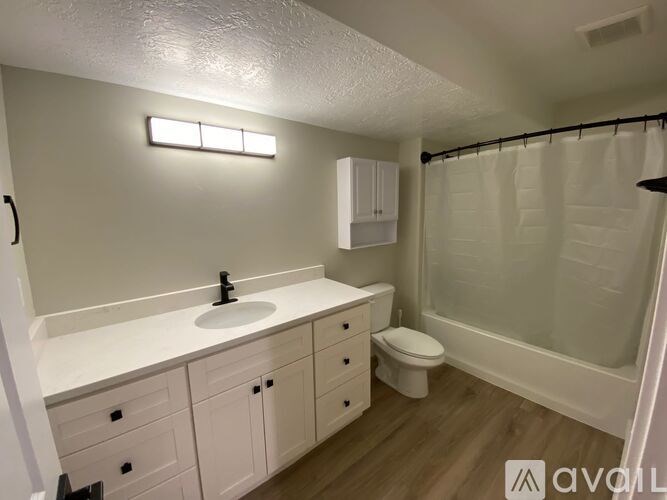 A bathroom with a sink, toilet, and shower.