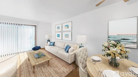 A living room with a white couch, a coffee table, and a painting on the wall.