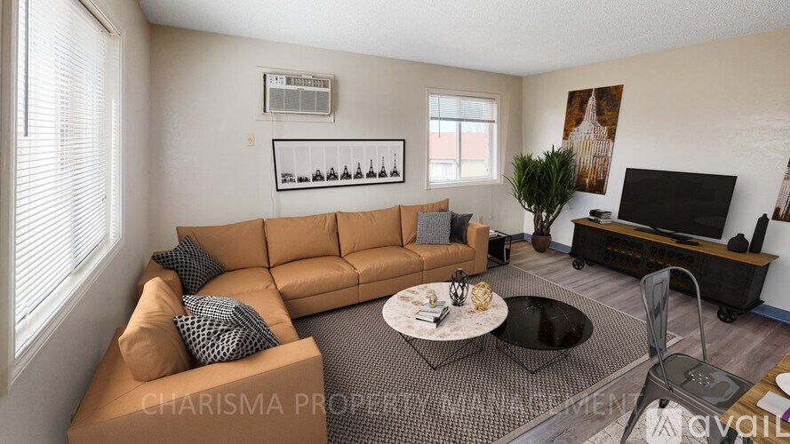 A living room with a brown sofa and a black coffee table.