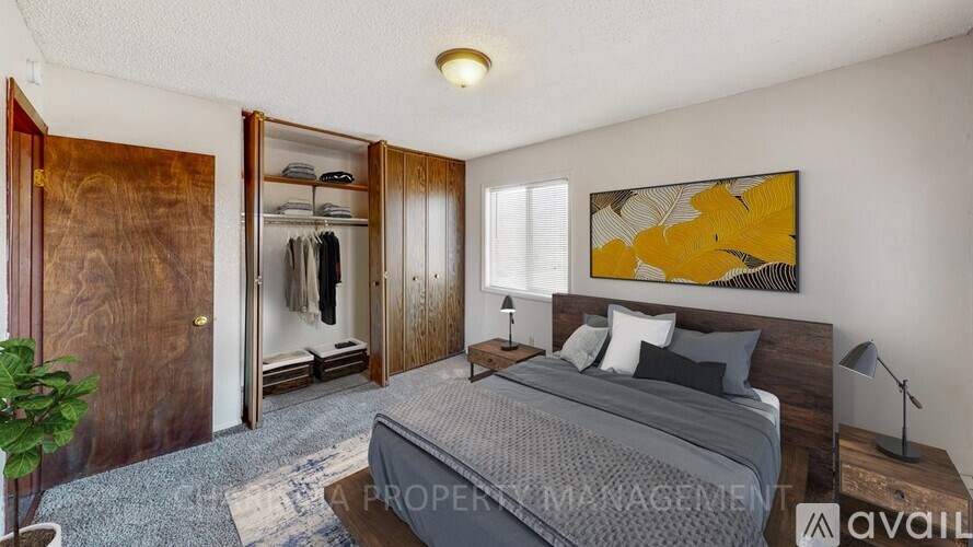 A bedroom with a bed, a dresser, and a painting on the wall.