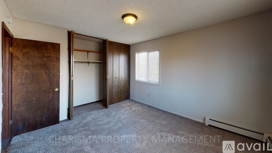 A room with a wooden door and a window with blinds.