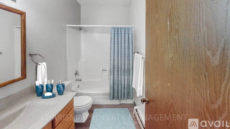 A bathroom with a toilet, sink, and shower.