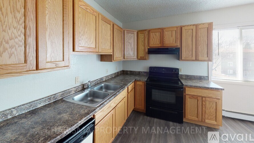 A kitchen with wooden cabinets and a black oven.