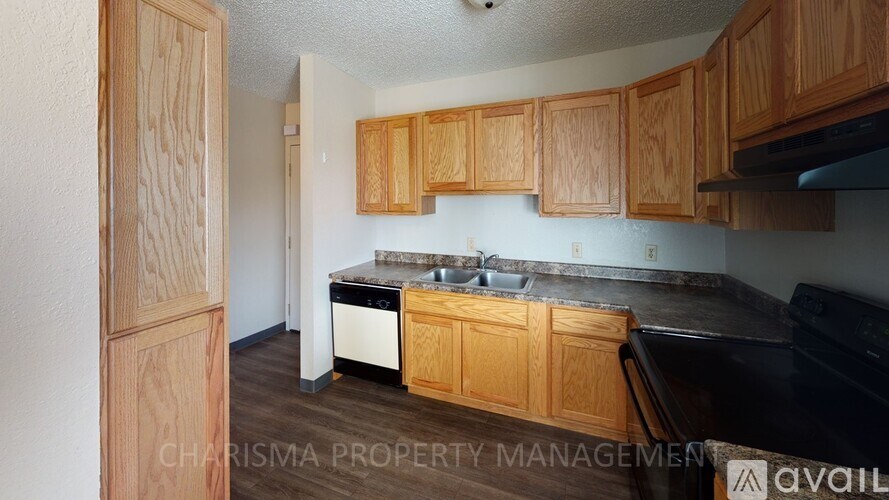 A kitchen with wooden cabinets and a black stove top oven.