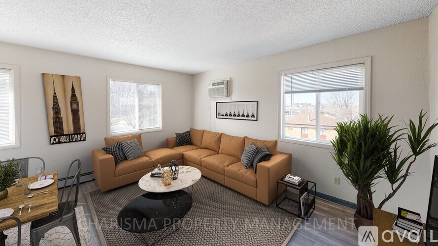 A living room with a brown sofa, a coffee table, and a TV.