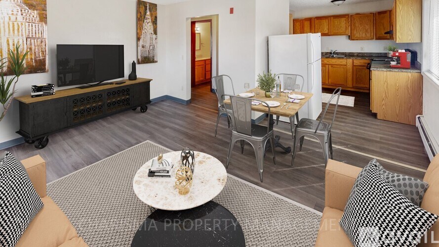 A living room with a grey rug and a white coffee table.