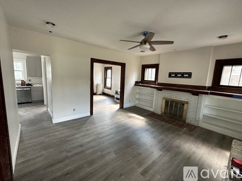 A living room with a fireplace and a ceiling fan.