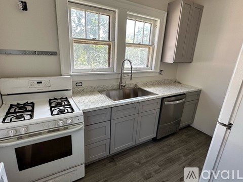 A kitchen with a white stove and a window.