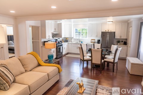 A modern living room with a beige sofa and a dining table set up.