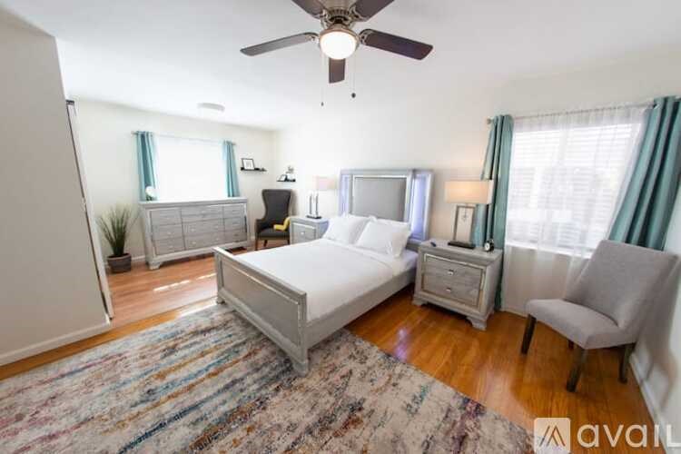 A bedroom with a bed, nightstand, and chair.