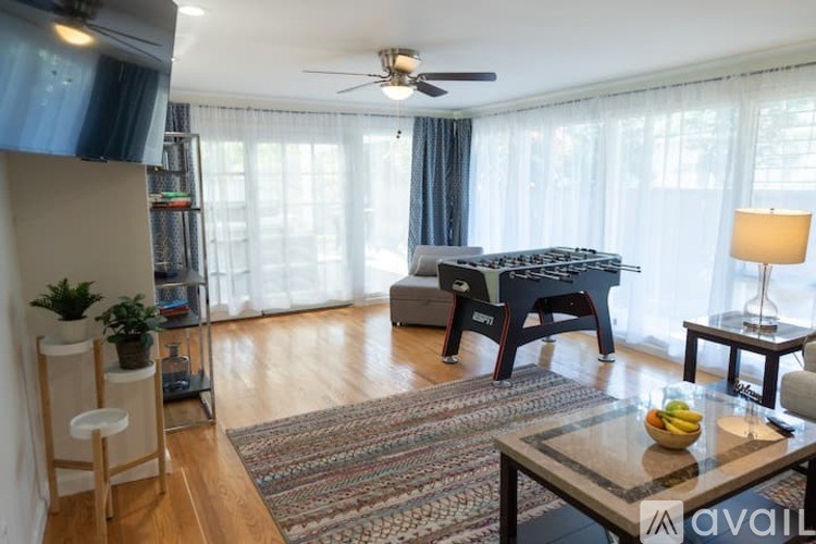 A living room with a pool table and a fan.