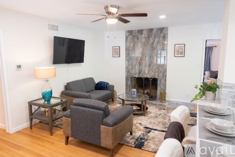 A living room with a grey couch and a fireplace.
