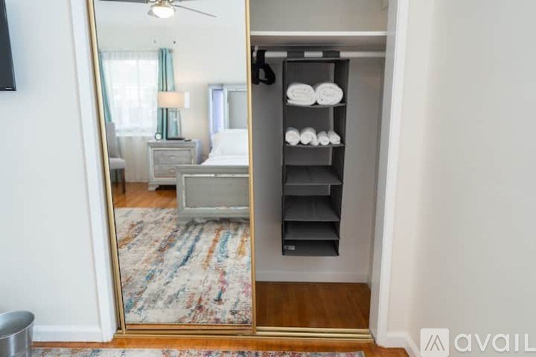 A bedroom with a large mirror and a built-in shelf.