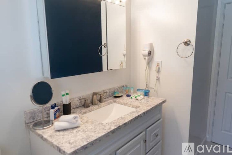 A bathroom with a sink, mirror, and toiletries.