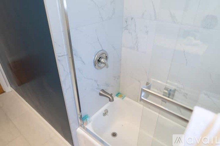 A bathroom with a white tub and a glass shower door.