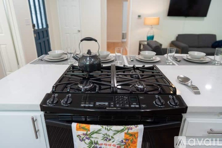 A black stove top with four burners is in the middle of a white counter.