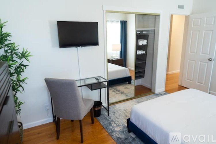 A bedroom with a bed, a chair, and a television.