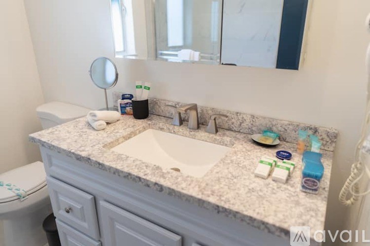 A bathroom with a marble countertop and a white toilet.
