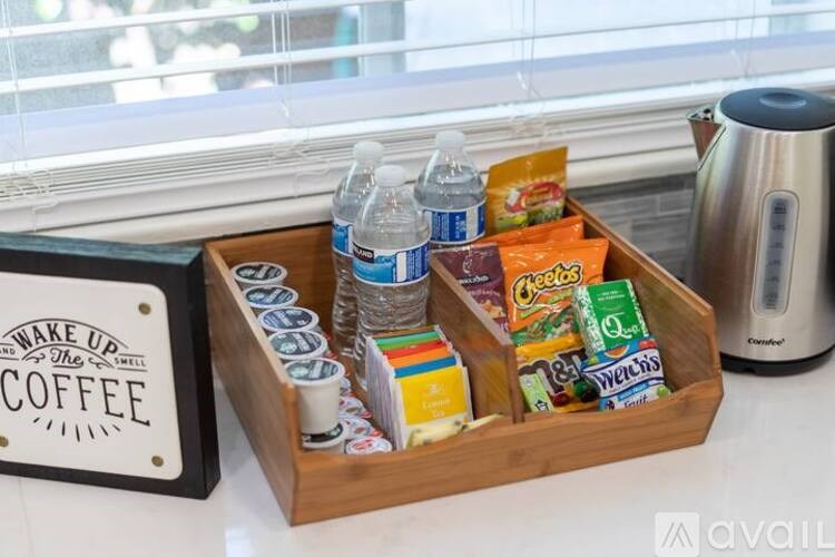 A wooden tray with coffee-making supplies and a sign that says "Wake up and smell the coffee".
