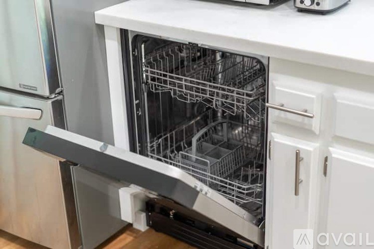 A white dishwasher with the door open and racks inside.