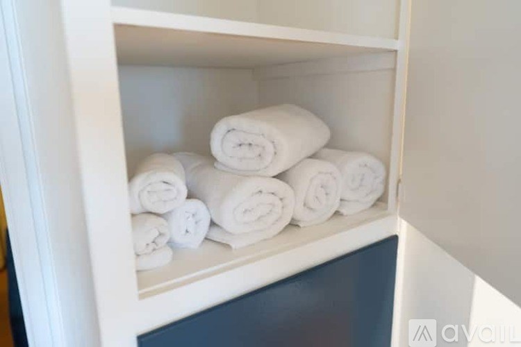 A white cabinet with towels on top.