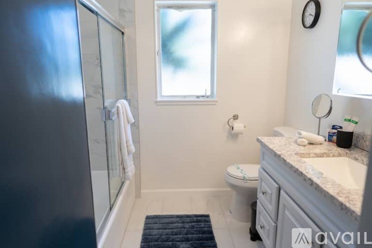 A bathroom with a toilet, sink, and mirror.